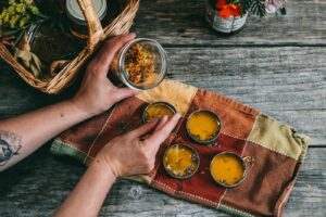 Natural health experiments to try this fall - person mixing up herbs into a salve